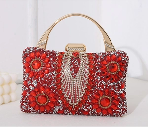 Macro detail of red rhinestone evening bag with intricate floral patterns and gold handle