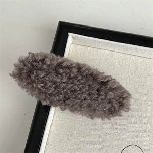 Close-up of brown plush faux fur oval hair clip with soft texture on a clean background