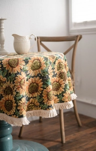 Close-up of thick sunflower jacquard tablecloth with elegant beige fringe tassels
