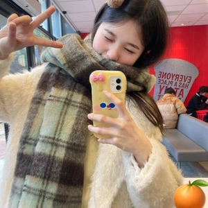 Close-up of a brown plaid scarf styled in a cozy cafe setting for a vintage autumn look