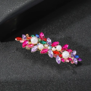 Barrette élégante avec strass colorés et perles sur fond noir texturé
