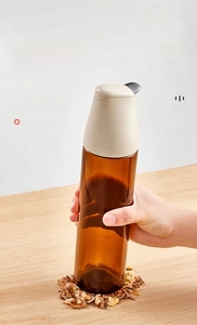 Makroaufnahme einer robusten braunen Glasölflasche, die eine Walnuss zerquetscht