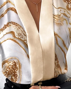 Detail of elegant V-neckline and golden marble print on women sleeveless satin blouse