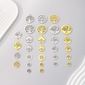 Plusieurs pendentifs Arbre de Vie en or et argent sur un fond gris propre et net