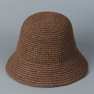 Detailed macro view of the hand-woven brown straw bucket hat texture and crochet craftsmanship