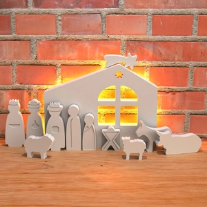 Belén minimalista de madera en mesa rústica con cálida iluminación de fondo suave