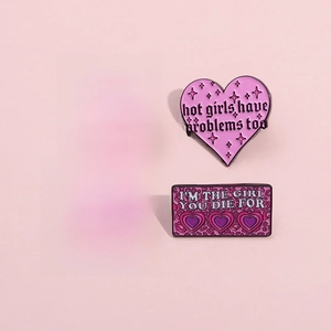 Set of four trendy enamel heart pins with slogans like Mood Reader on pink background