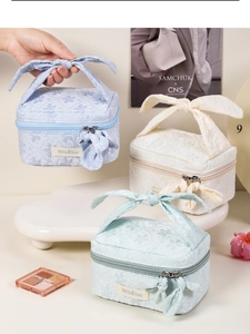 Detailed shot of jacquard cosmetic bags with floral embroidery and bow tie handles