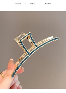 Detailed close-up of a large gold hair claw clip set with deep blue sparkling rhinestones