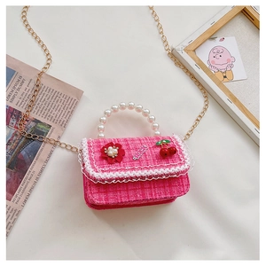 Detail of pink tweed girl's bag with pearl handle, lace trim, and gold chain strap