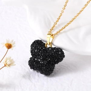 Vue macro d'un collier doré avec pendentif papillon noir orné de détails en résine