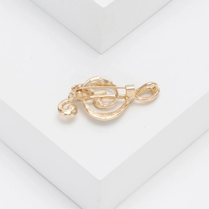 Detail view of the pin fastening on the back of a gold musical note brooch