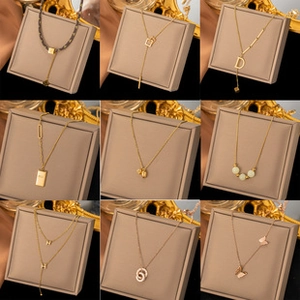 Macro view of assorted zircon necklaces in gold and rose gold finishes on beige jewelry boxes