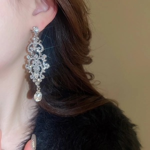 Detailed view of silver drop earrings with crystals on a model for luxury fashion styling