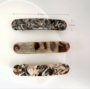 Detailed view of hair clips set with rhinestone flowers and 8.5cm size markings