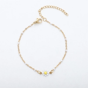 Detail of 18K gold daisy bracelet with white enamel petals and small bead accents