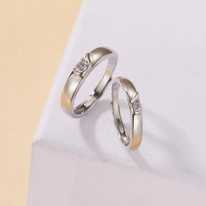 Macro shot of S925 sterling silver couple rings with gold heartbeat line and zircon inlay