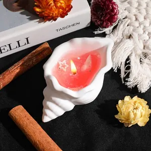 Artistic conch shell scented candle with pink jelly wax and star decor on black fabric