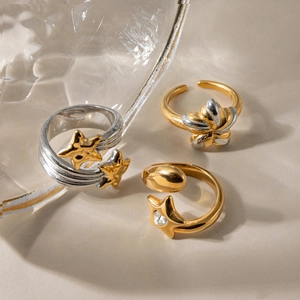 Detailed view of color-blocked star rings with cubic zirconia on a textured surface