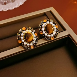 Detailed shot of vintage tiger eye earrings with small pearls and crystals in a gift box