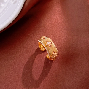Detail of gold-plated wide ring featuring brushed texture and zircon star pattern inlay
