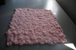 Close-up of thick pink artificial silk moss with soft fiber texture for landscape decor