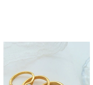 Close-up of golden lace texture rings on white fabric with detailed relief engraving