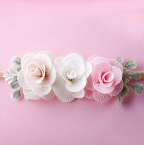Detail of baby headband with white and pink fabric roses and soft elastic nylon band