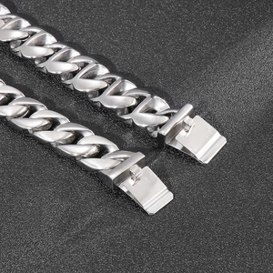 Detail of heavy cuban chain and textured heart link with secure clasp closure