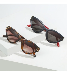 Close-up of cat-eye sunglasses with tortoiseshell and black-red frames with gold metal accents