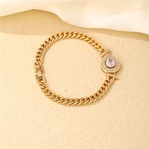 Detailed close-up of golden flat Cuban chain bracelet with pear-shaped zircon pendant