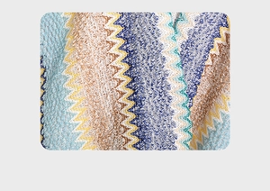 Macro shot of ethnic knitted fabric featuring blue and brown chevron wave patterns