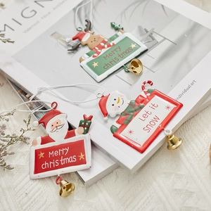 Christmas metal ornaments featuring Santa, deer, and snowman with gold bells and hanging ropes