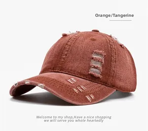 Detailed view of the distressed texture and ripped fabric on this tangerine baseball cap