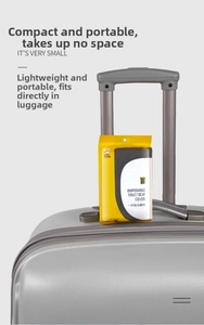 Portable disposable toilet seat cover next to a silver suitcase for travel use