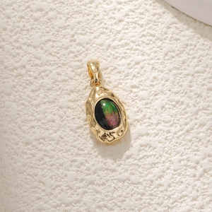 Macro shot of gold-plated abalone shell pendant with iridescent opal-like inlay