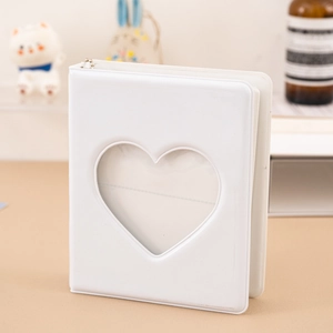 Close-up of a white 3-inch photo album with a heart-shaped cutout and silver chain