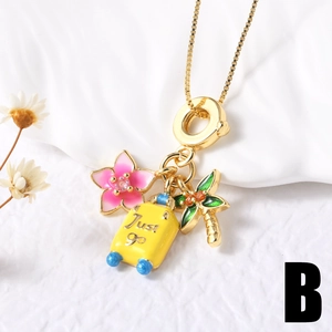 Close-up of gold chain featuring enamel flower, suitcase, and palm tree travel pendants
