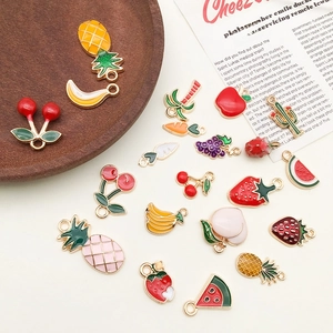 Macro shot of assorted colorful enamel fruit charms including cherries and pineapples
