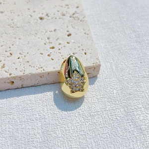 Macro shot of gold-plated egg pendant featuring a sparkling zircon-encrusted star detail