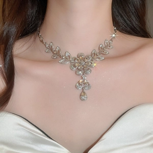 Macro shot of a floral silver necklace with sparkling crystals and a teardrop pendant