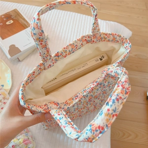 Top view of floral quilted handbag showing spacious beige interior and opening design