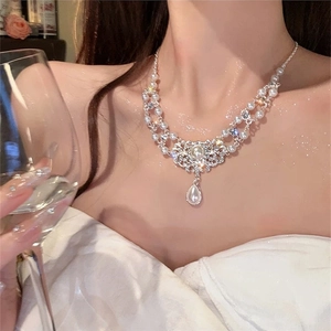 Detail of plush bow pearl necklace with lace rhinestone centerpiece and teardrop pendant