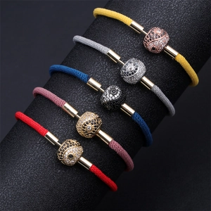 Close-up of adjustable woven cord bracelets in five colors with yin yang charms