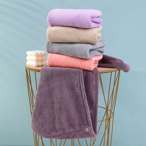 Detail of colorful coral fleece hair towels stacked with buttons on a metal table