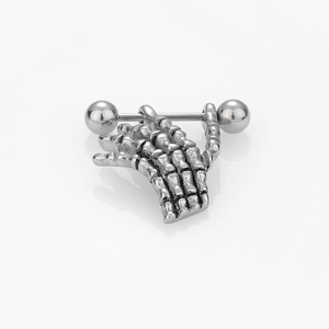 Vue macro du piercing de mamelon en acier inoxydable avec main de squelette sur fond blanc