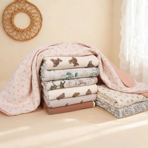 Detailed stack of soft multi-layered cotton baby swaddle blankets in various prints