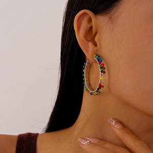 Close-up of multicolor faceted crystal beads on large metal hoop earrings for women