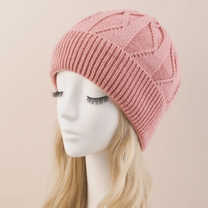 Primer plano de gorro de punto rosa con patrones de ondas texturizados y borde de canalé