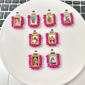 Detail view of eight rectangular religious pendants with pink beads and golden frames